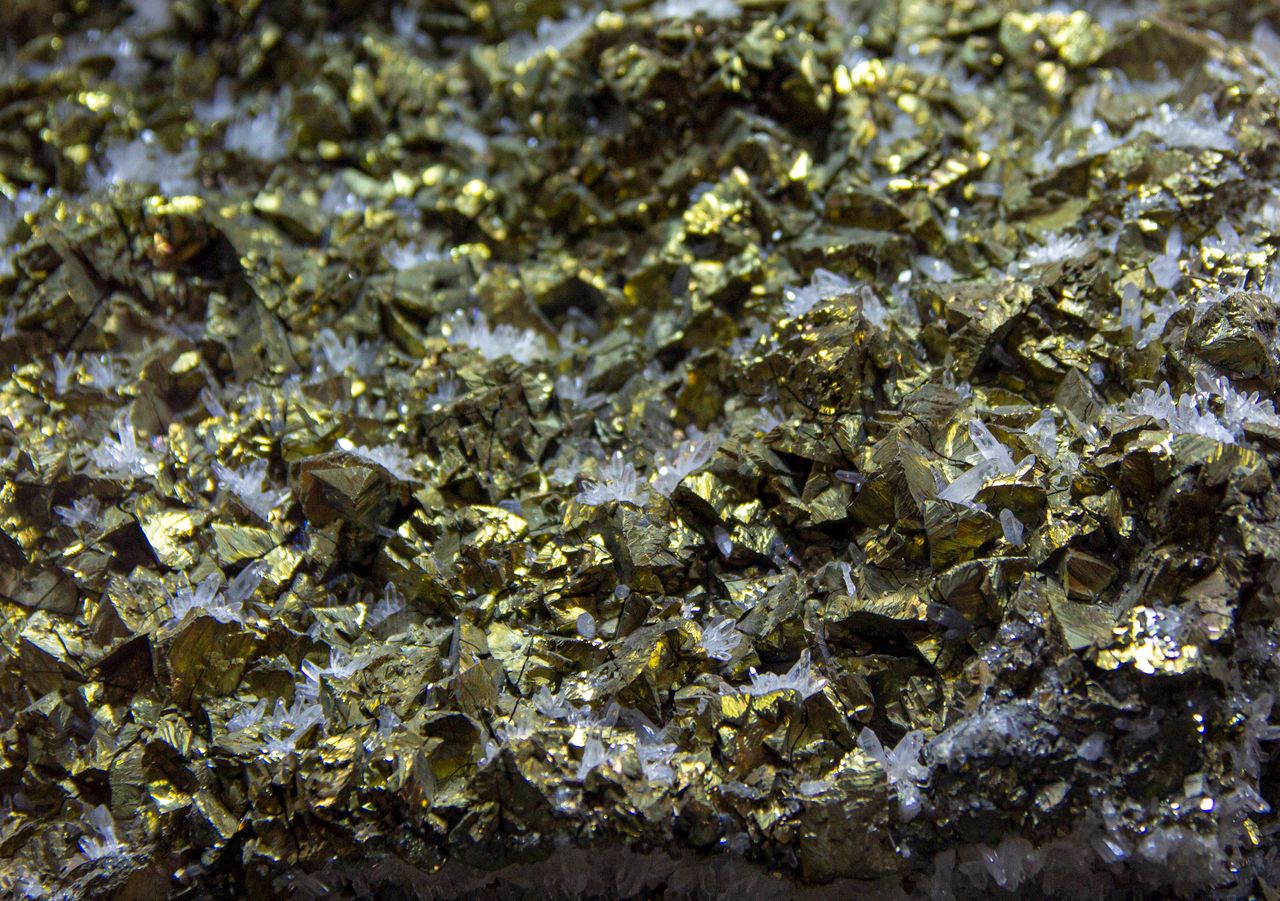 Intricate close-up of pyrite and crystalline formations showcasing glittery, textured appearance.